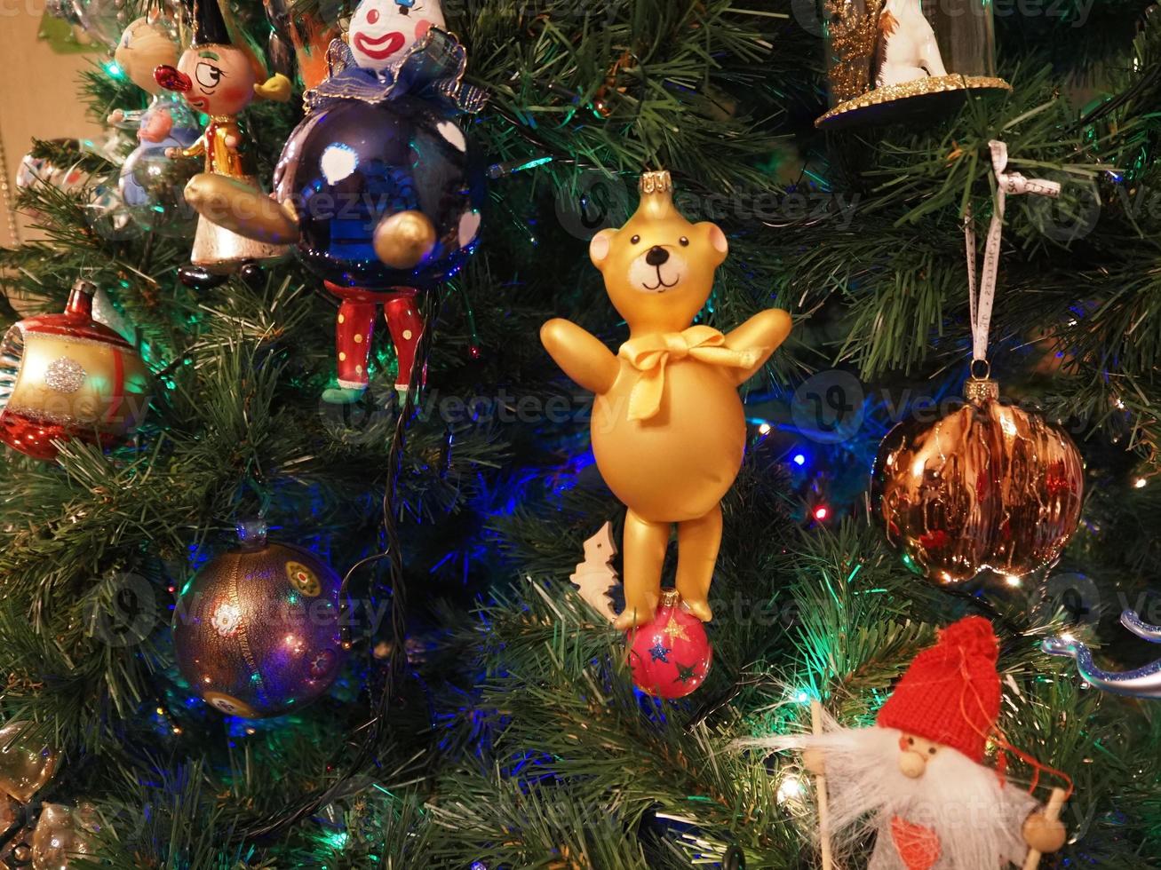 bola de navidad hecha a mano de vidrio en el detalle del árbol de navidad luces borrosas foto