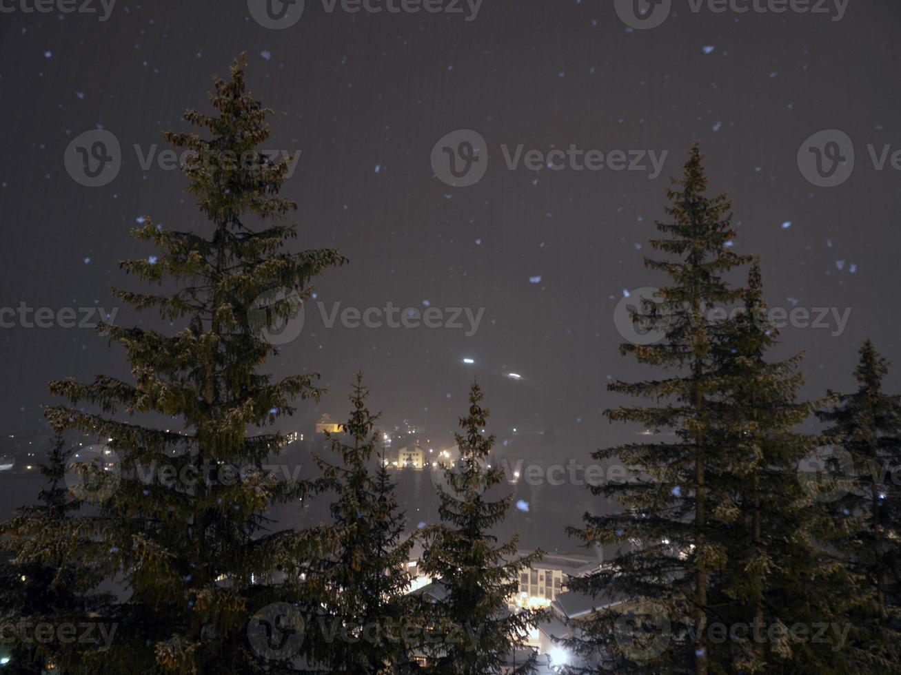 snowing at night in dolomites mountains photo