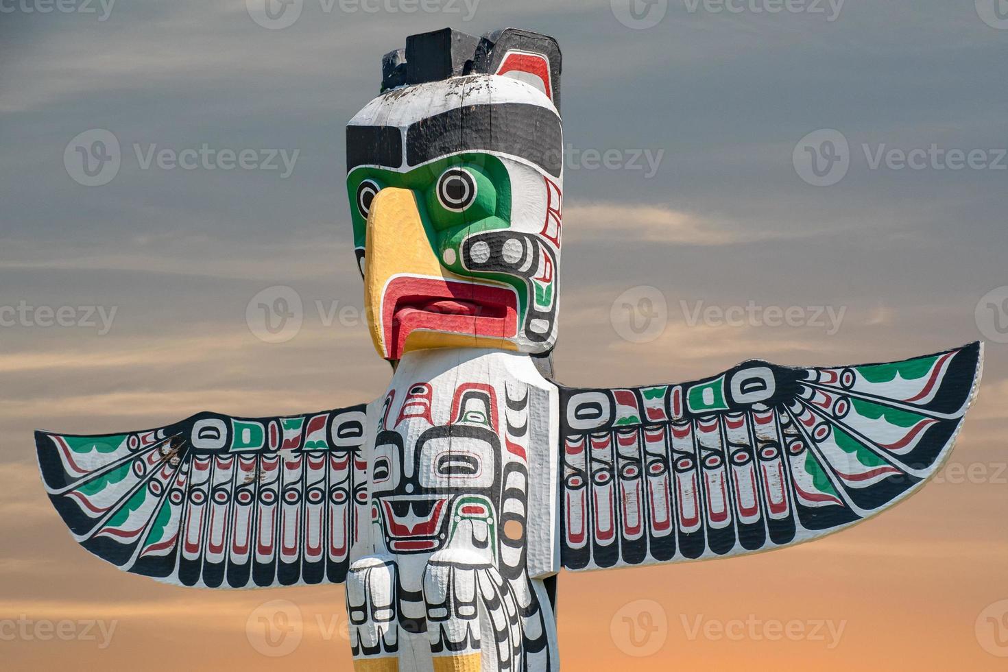 Totem wood pole in sunset background photo