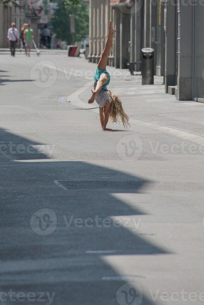 niño niña haciendo voltereta en el calle foto