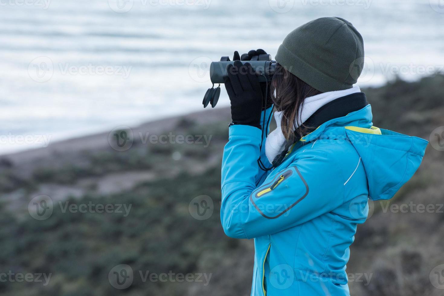 girl looking sea with binoculars photo