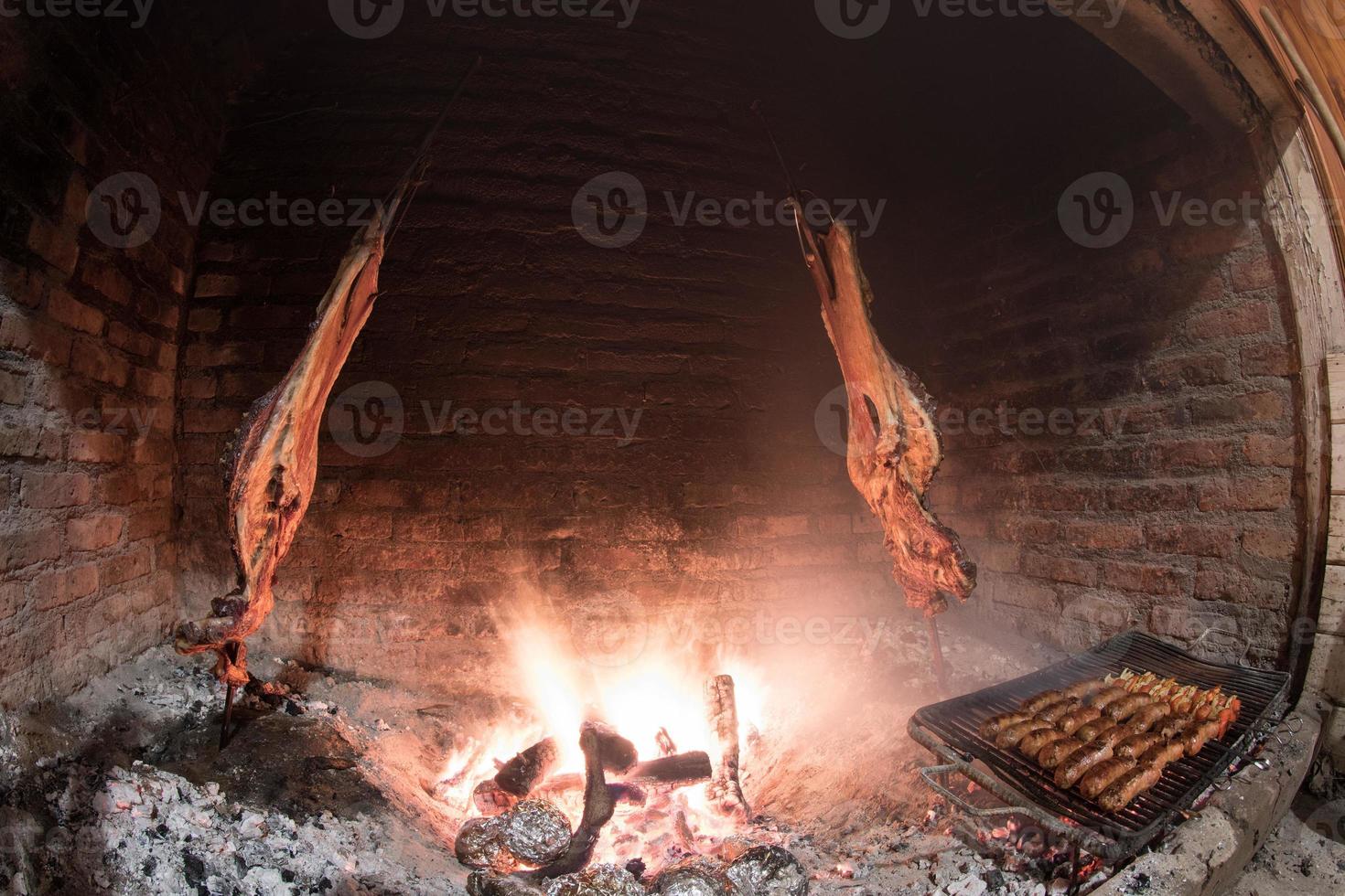 Asado cooking in ancient fireplace photo