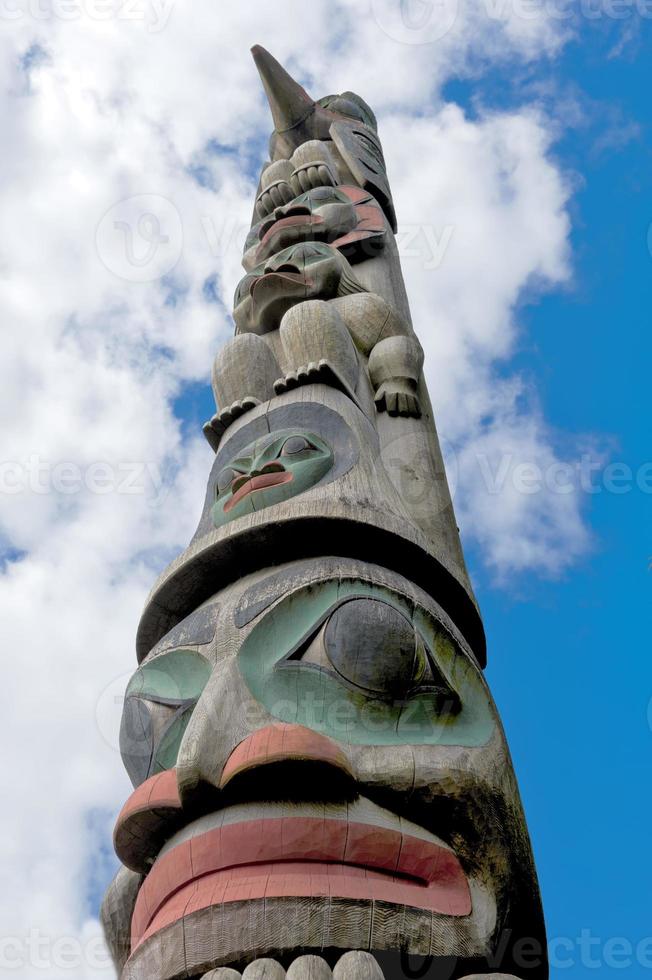 A totem wood pole in the blue cloudy background photo