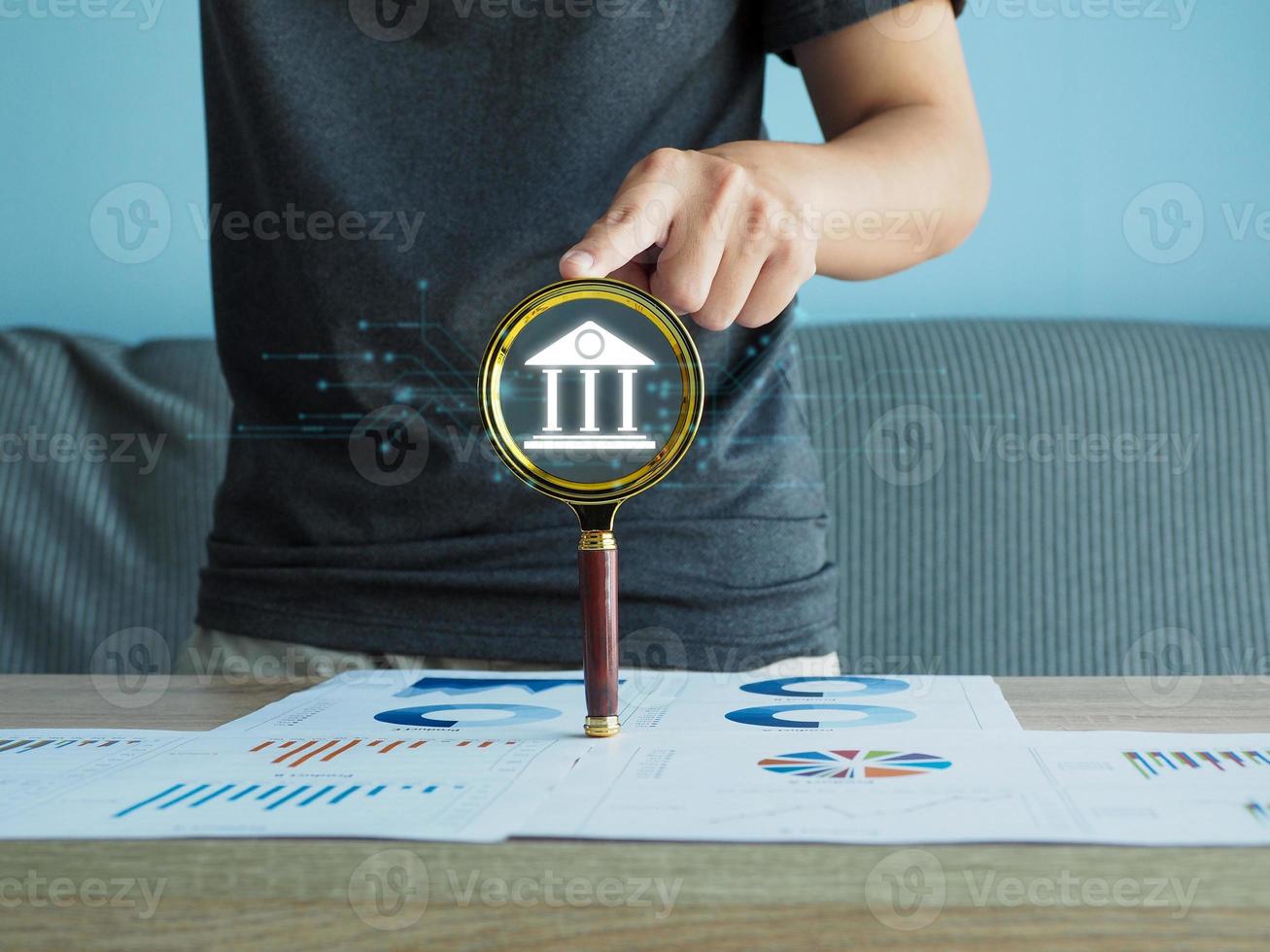 a man with a magnifying glass searching bank icon finance investment return loan photo