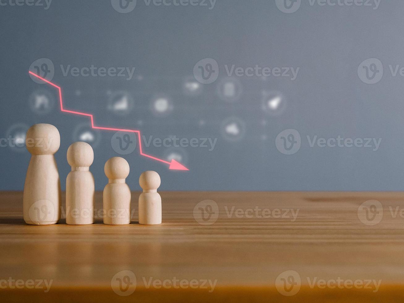 Man made of wood with a falling graph. Global financial crisis. The performance of the team is deteriorating. The readiness of the team that is going into recession. photo