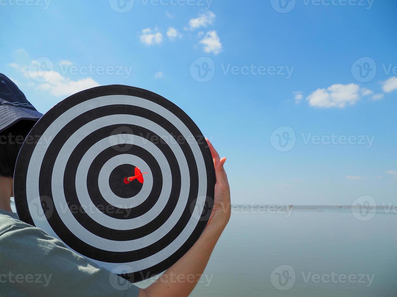 young business woman carrying success goals the concept of business There is a red dart in the center of the target. photo