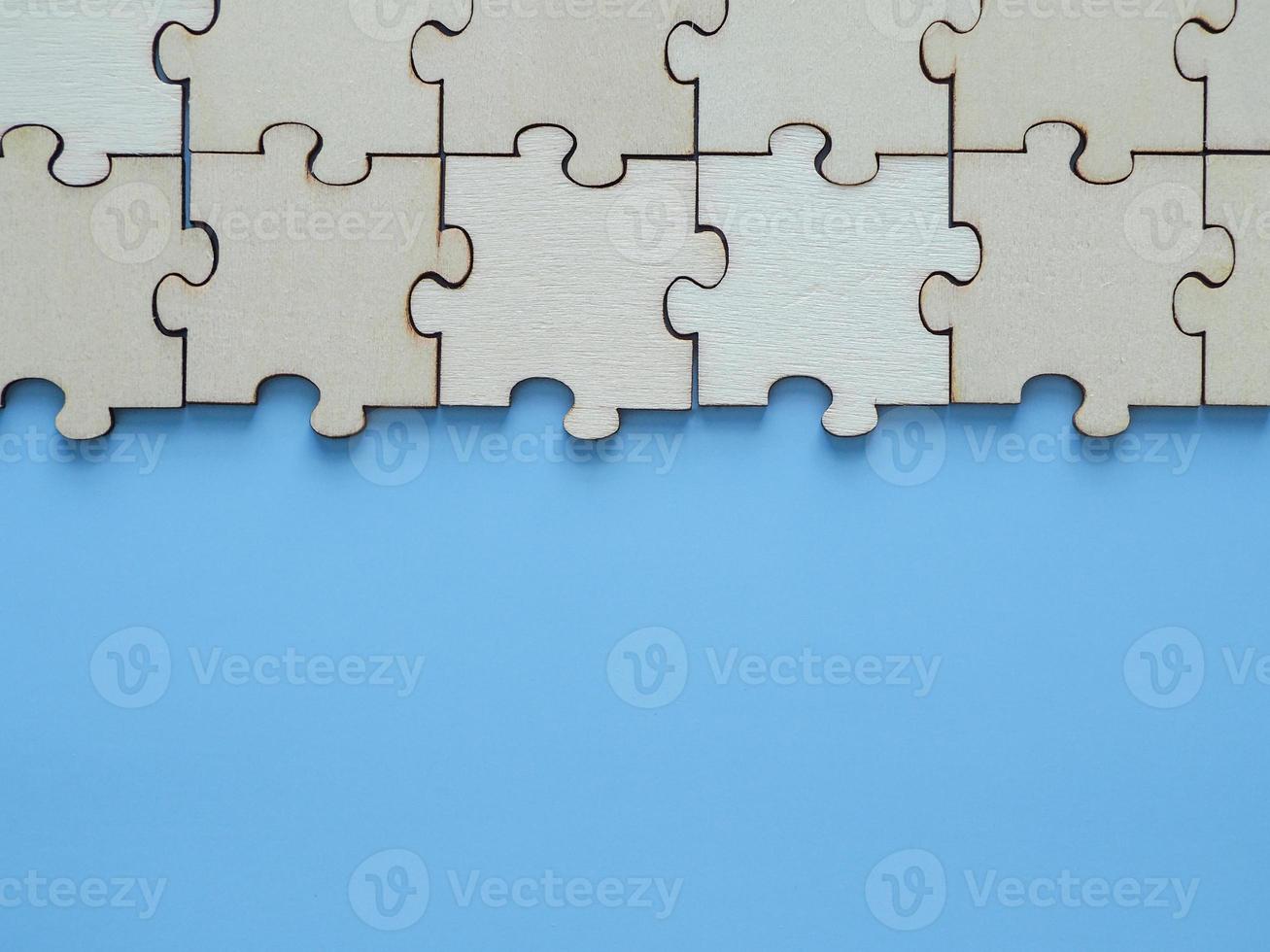 Complete wooden jigsaw puzzles business cooperation on a blue background photo