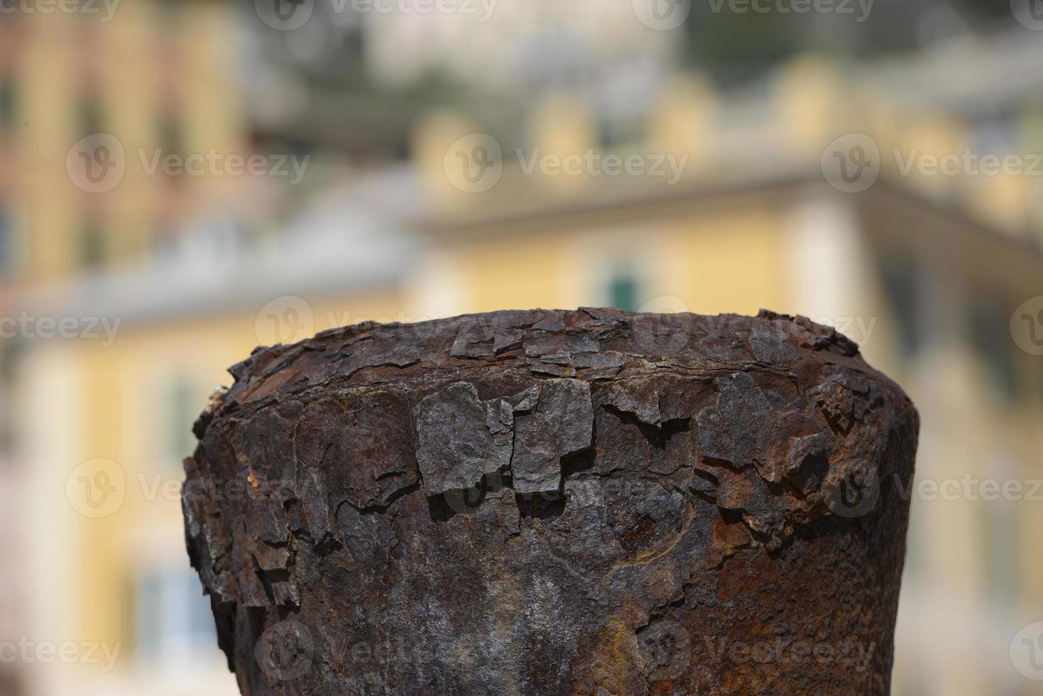 Rusted Bollard on colorful building background photo