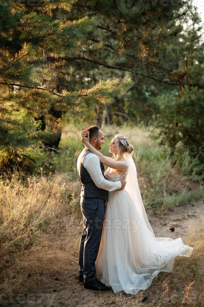 the groom and the bride are walking in the forest photo