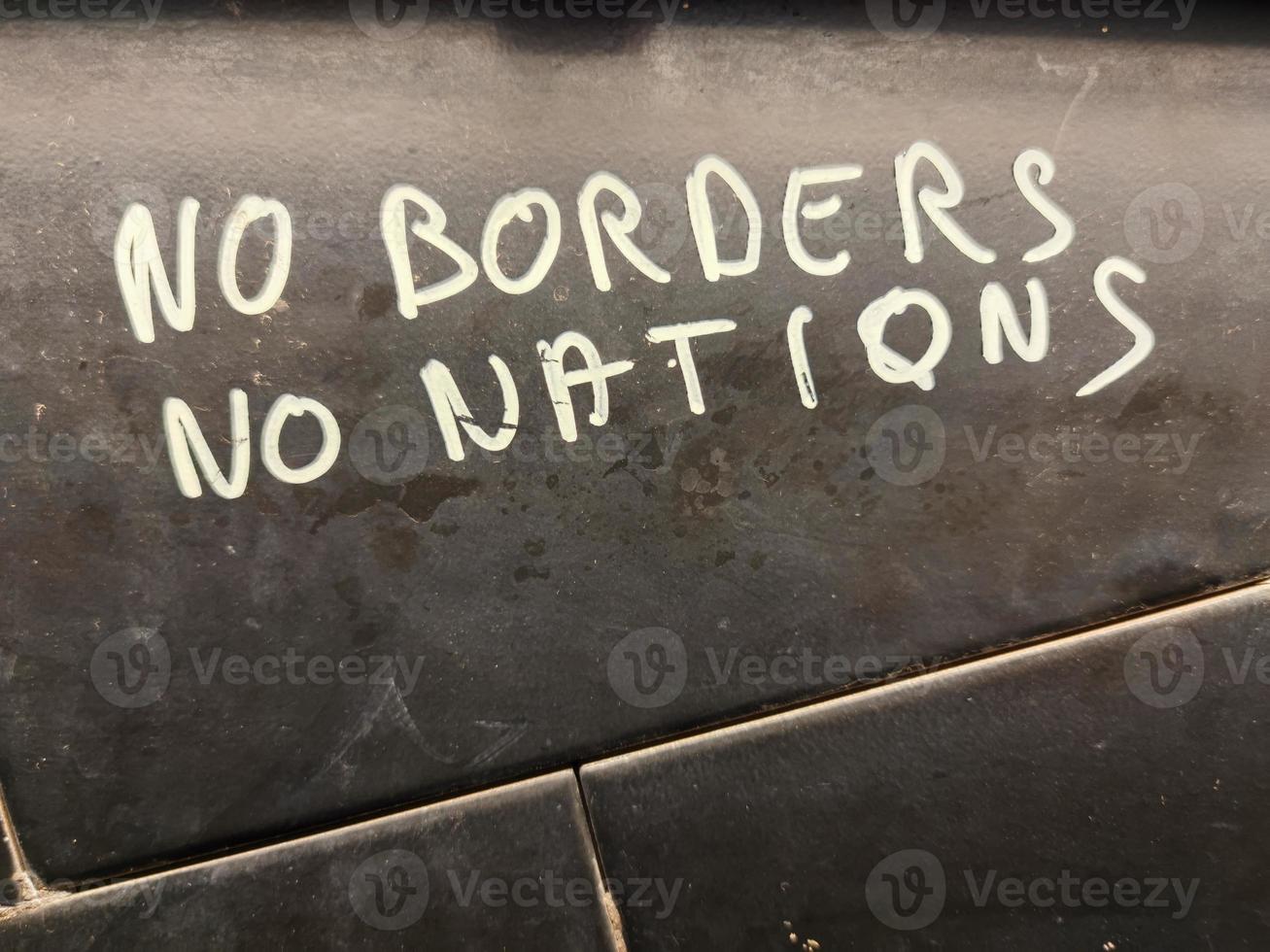 no borders no nations hand writing on a wall photo