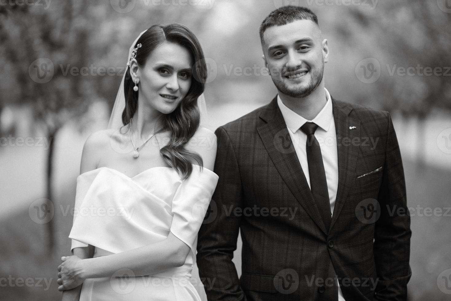 recién casados caminar en el parque entre Cereza flores foto