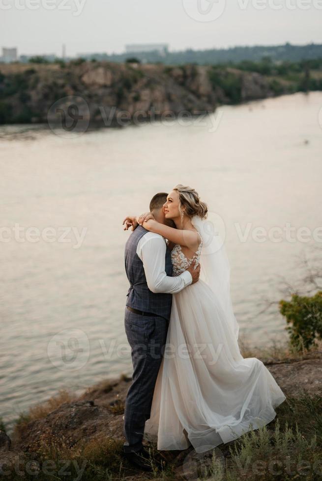 bride blonde girl and groom near the river photo