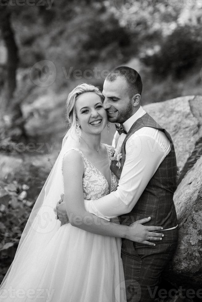 the groom and the bride are walking in the forest photo
