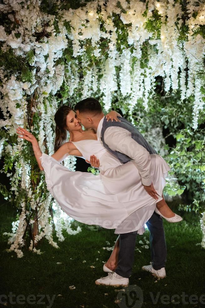 couple of newlyweds on the evening illuminated arch photo