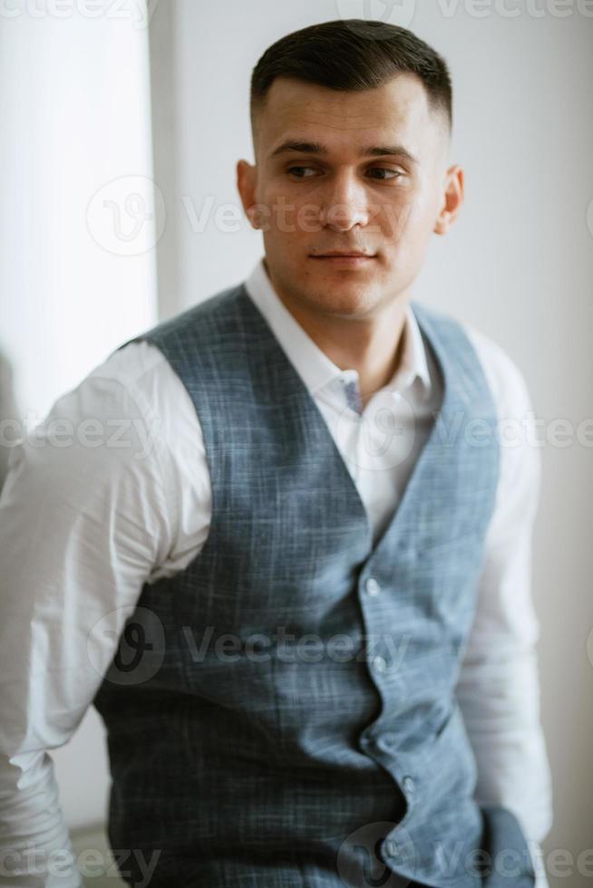 portrait of the groom in a light gray suit photo