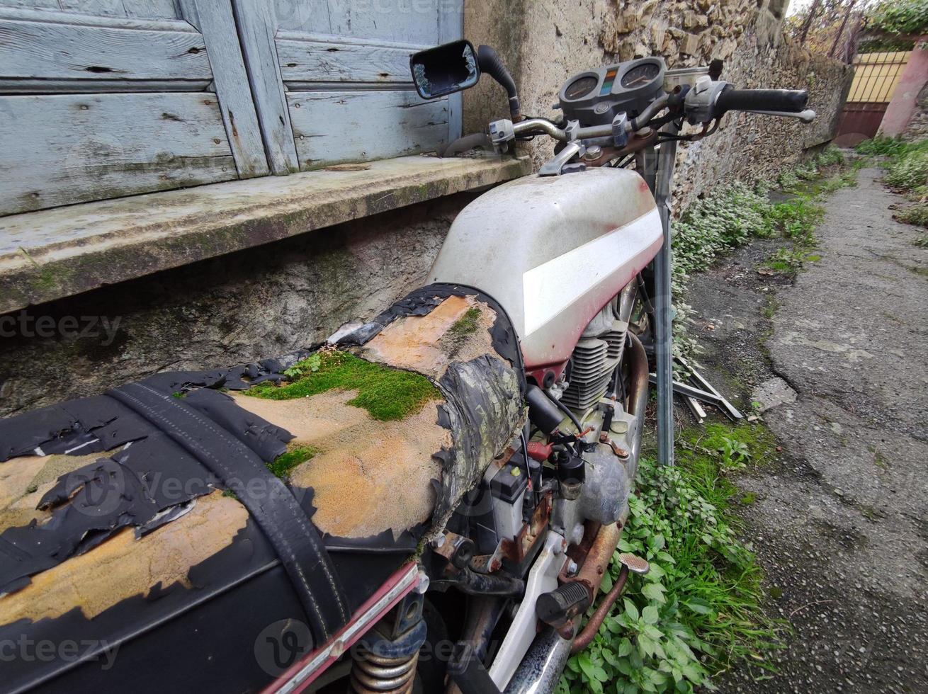 abandoned bike with moss on saddle photo