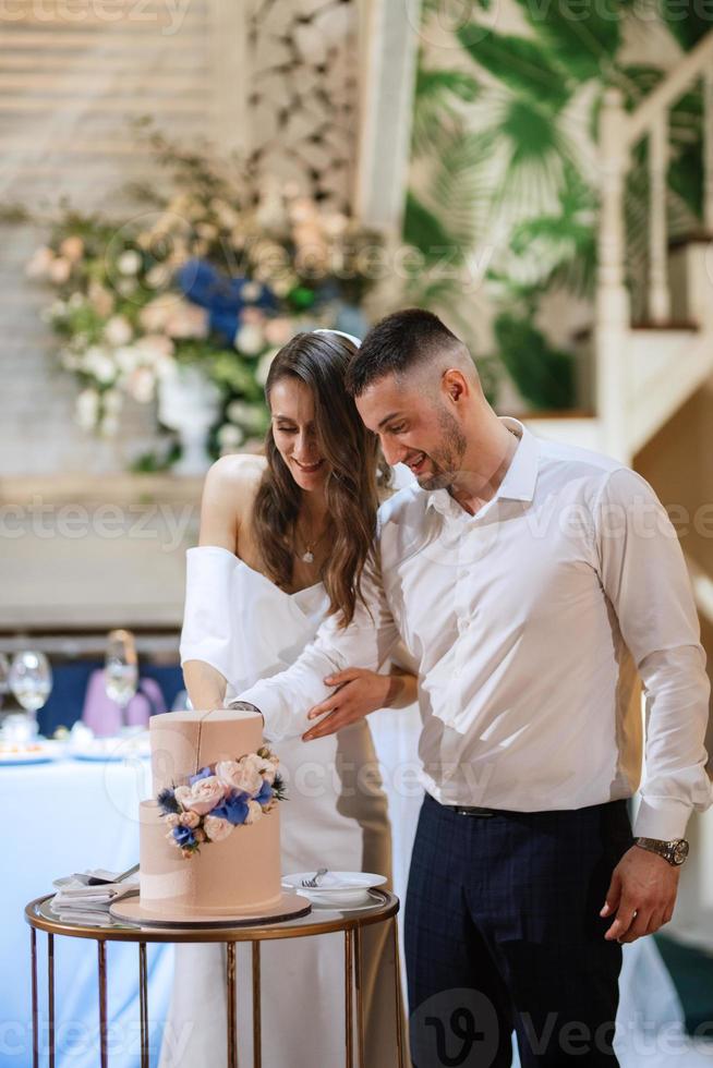 newlyweds happily cut and taste the wedding cake photo