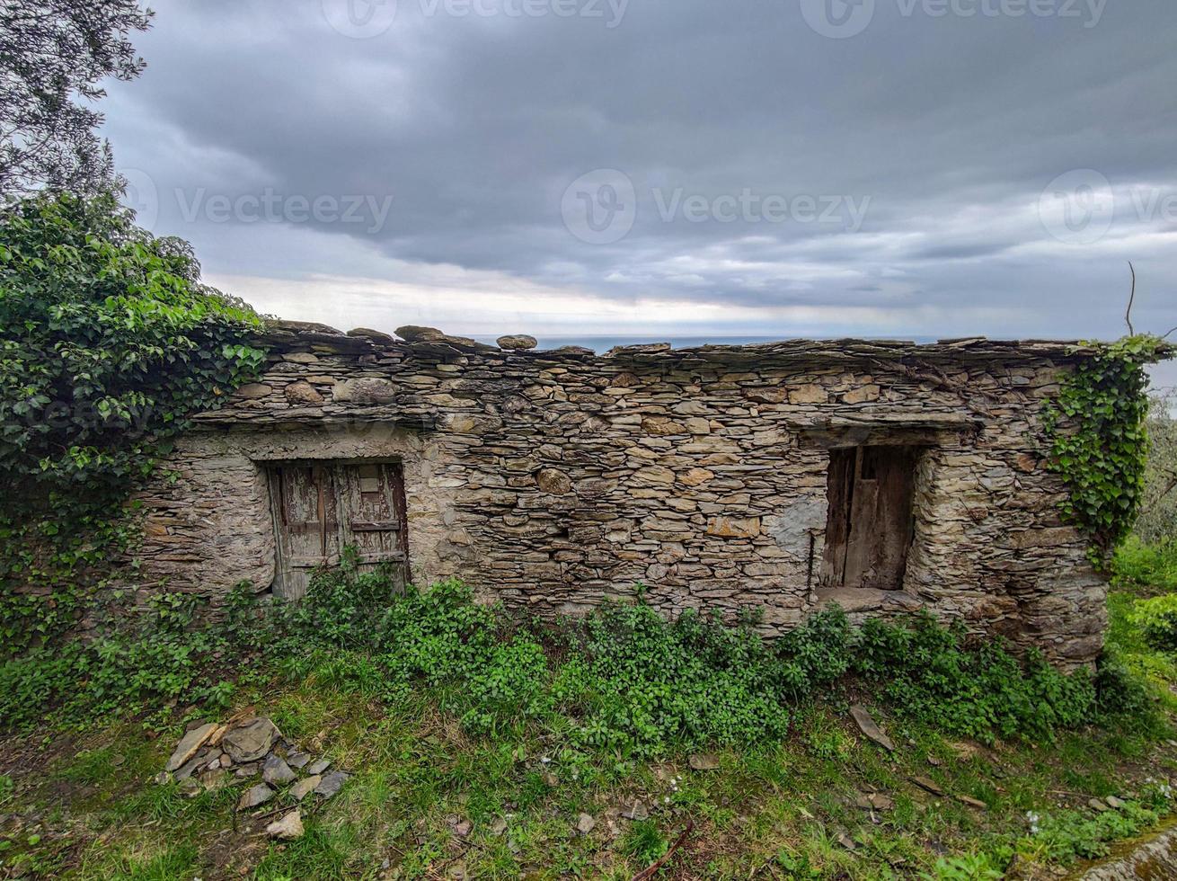 Old stone house by the sea hill in Liguria photo