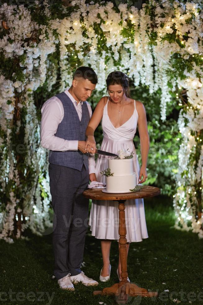 newlyweds happily cut and taste the wedding cake photo