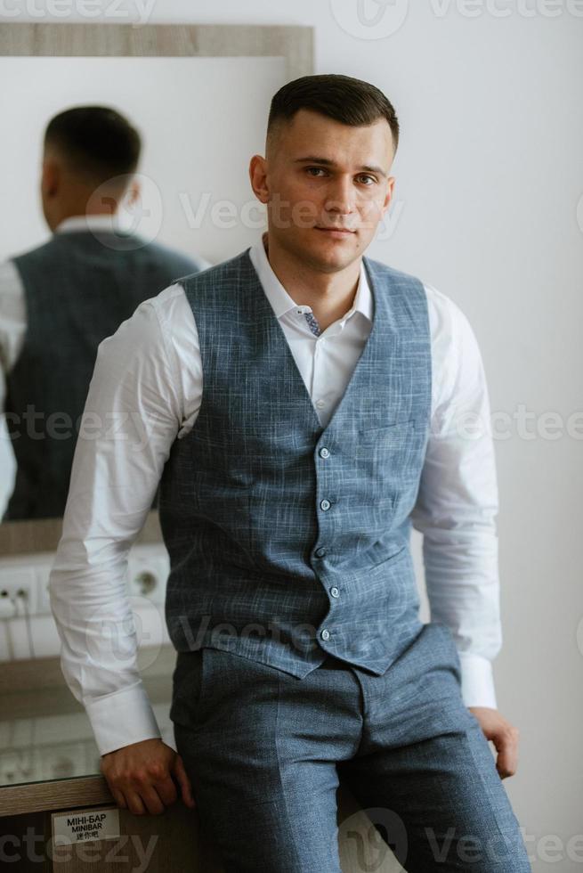 portrait of the groom in a light gray suit photo