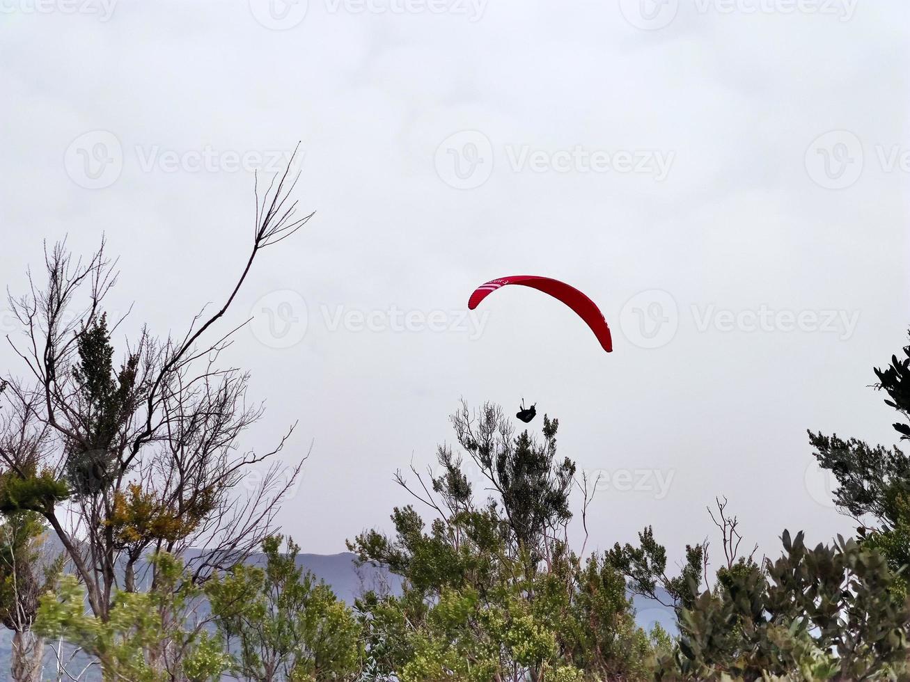 paraglider on cloudy sky in monterosso cinque terre italy photo