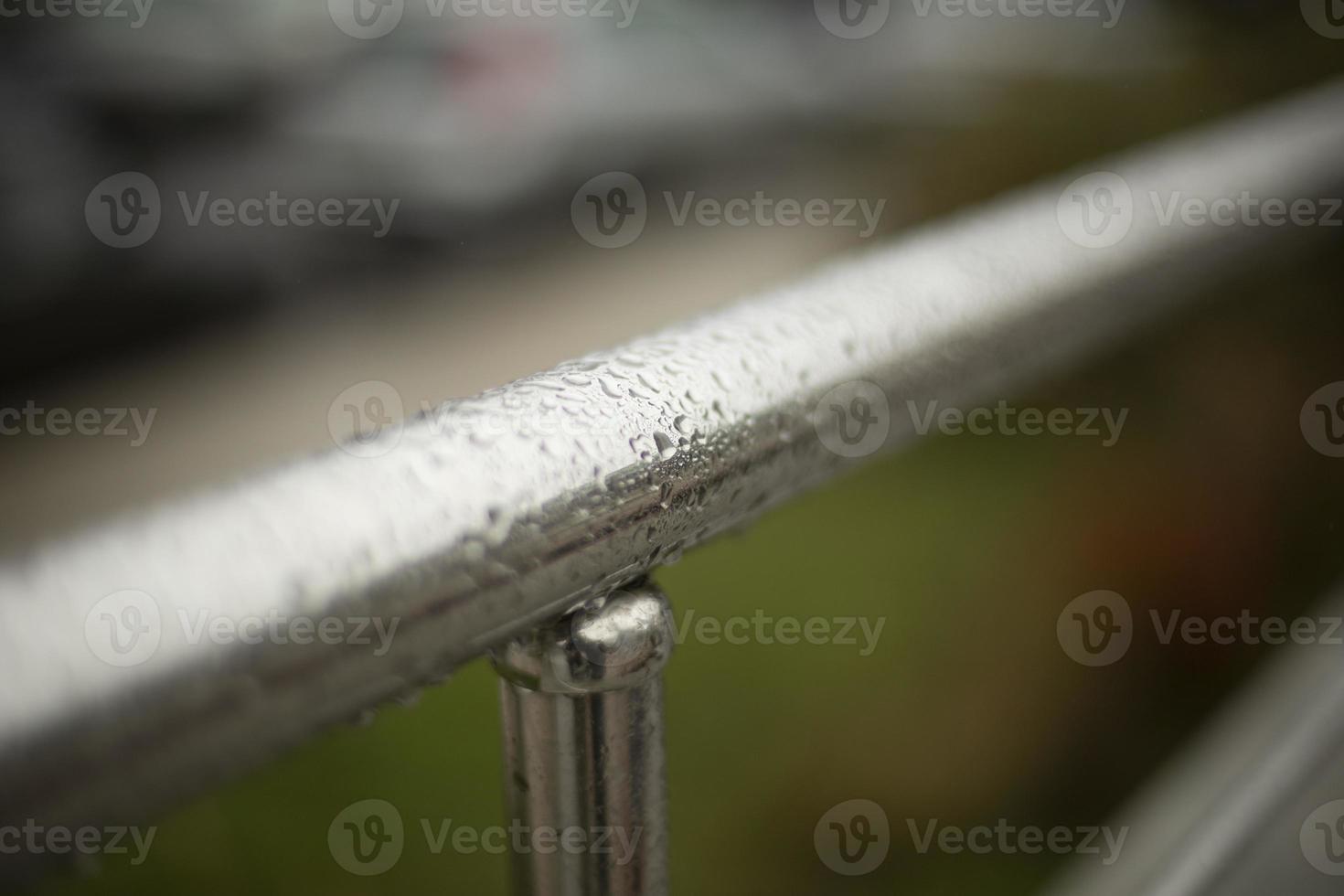 Wet handrail. Steel pipe in water droplets. Silver steel pole. photo