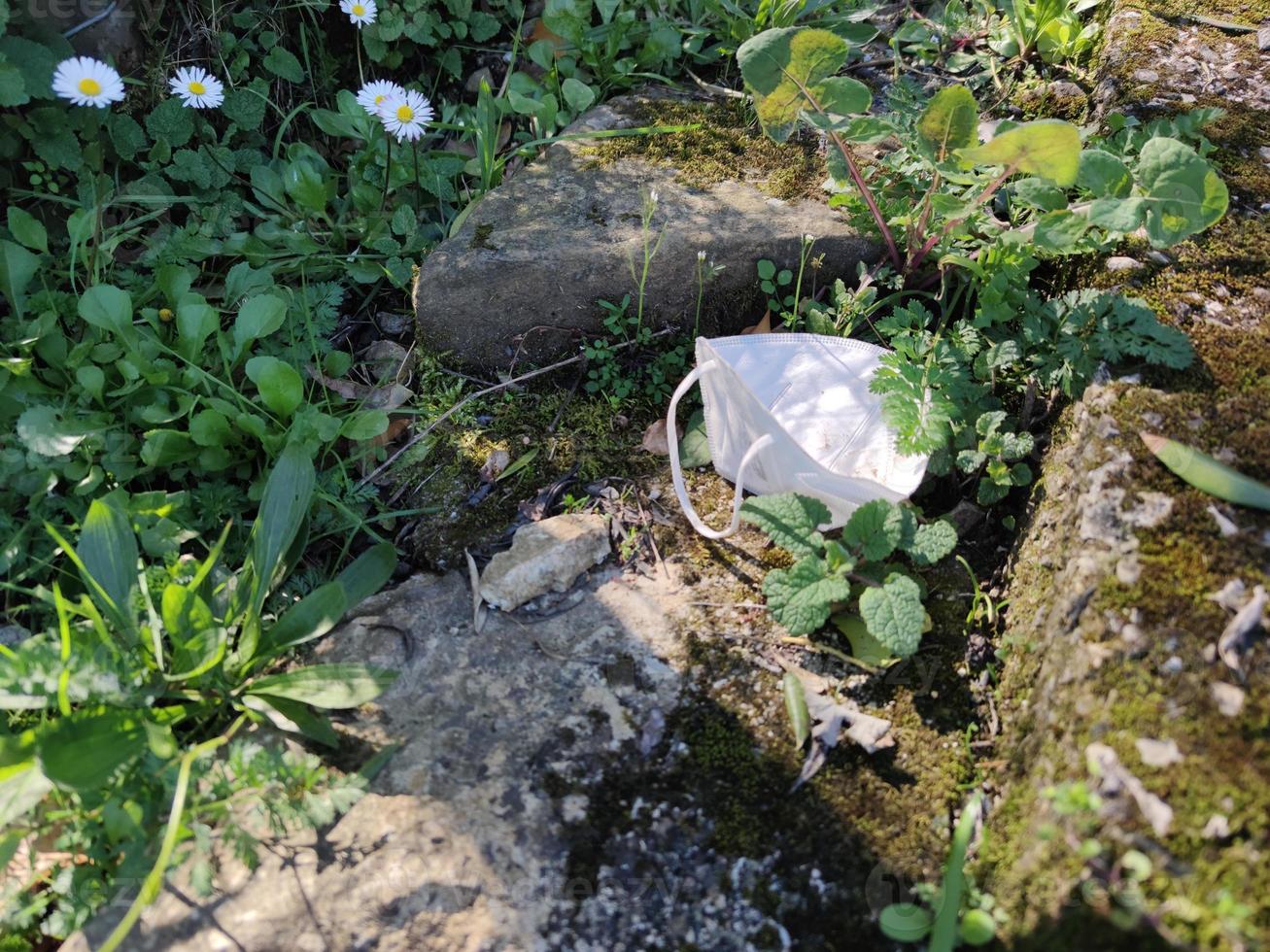abandoned covid mask on a trail path photo