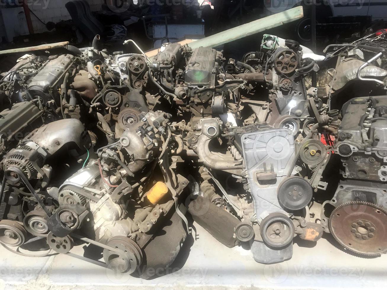 many old used car engine and parts photo