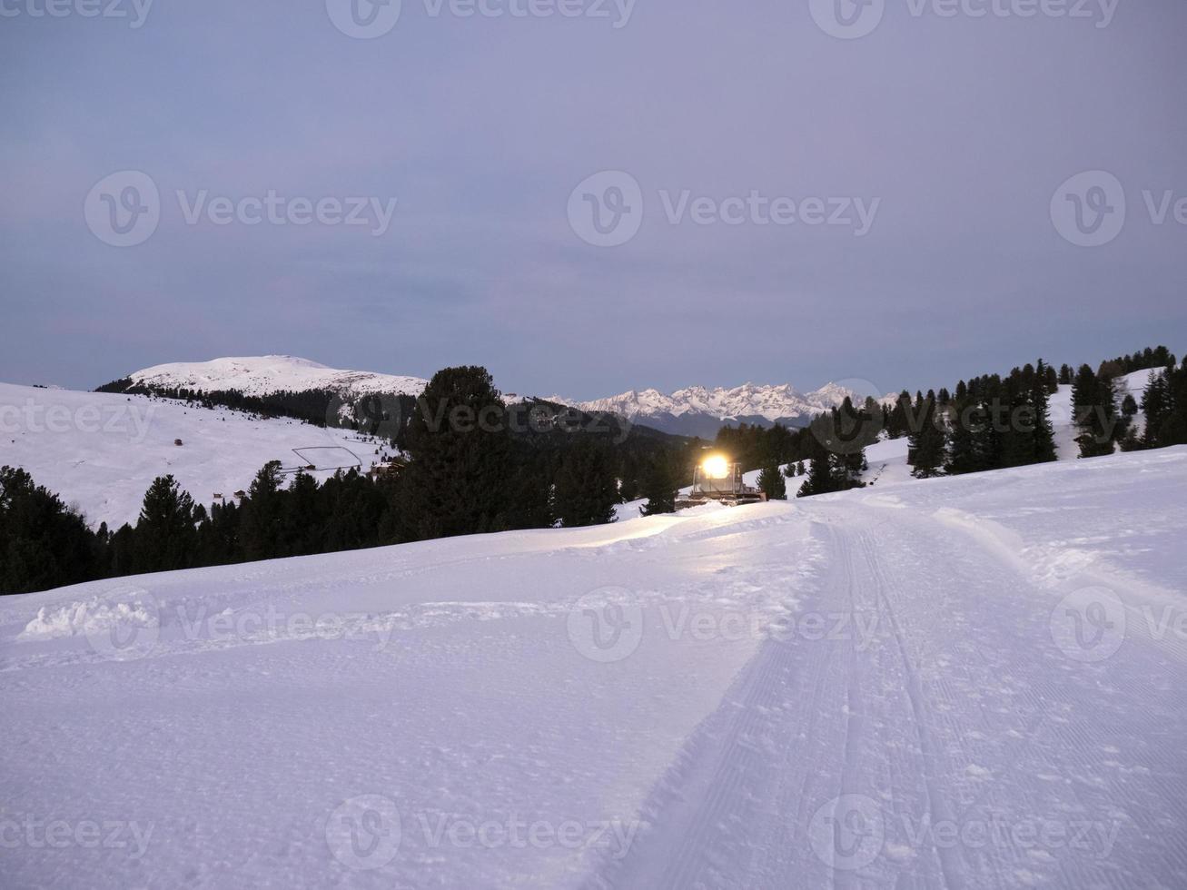 moto de nieve en pista de esquí por la noche foto