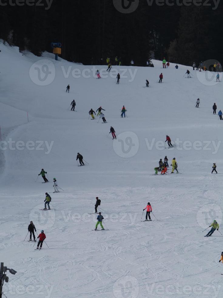 many skiers skiing in dolomites gardena valley snow mountains photo