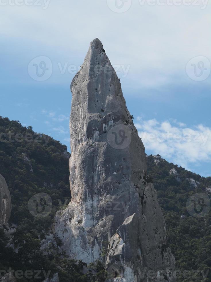 Escalador en acantilado de roca goloritze por el mar Cerdeña Italia foto