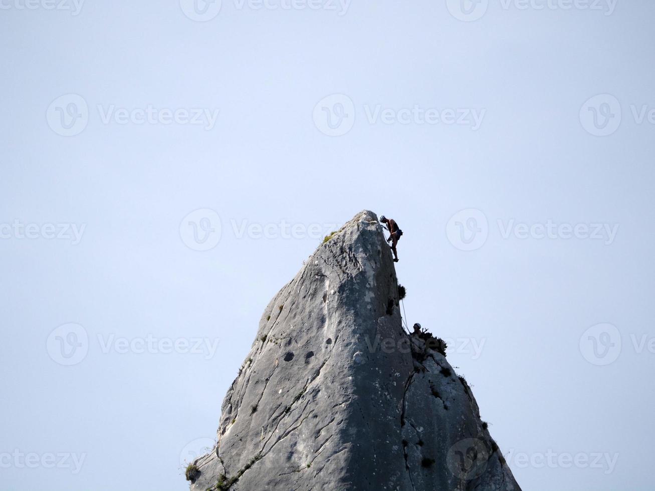 Escalador en acantilado de roca goloritze por el mar Cerdeña Italia foto