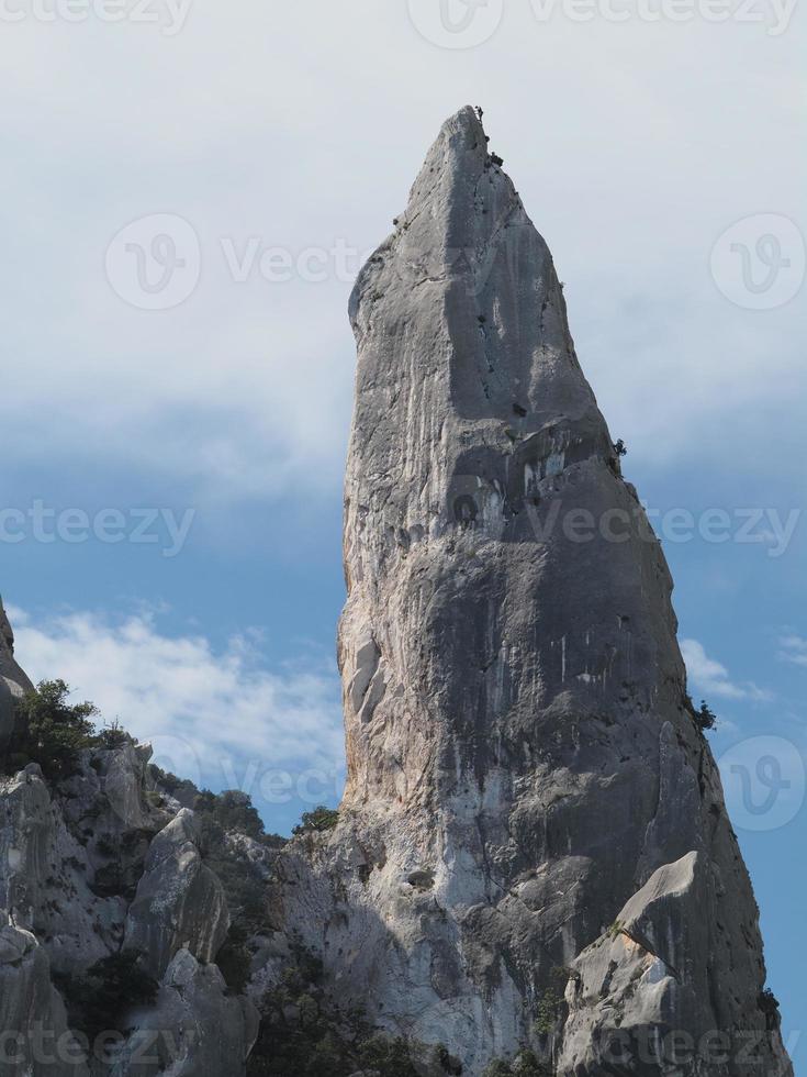 Escalador en acantilado de roca goloritze por el mar Cerdeña Italia foto