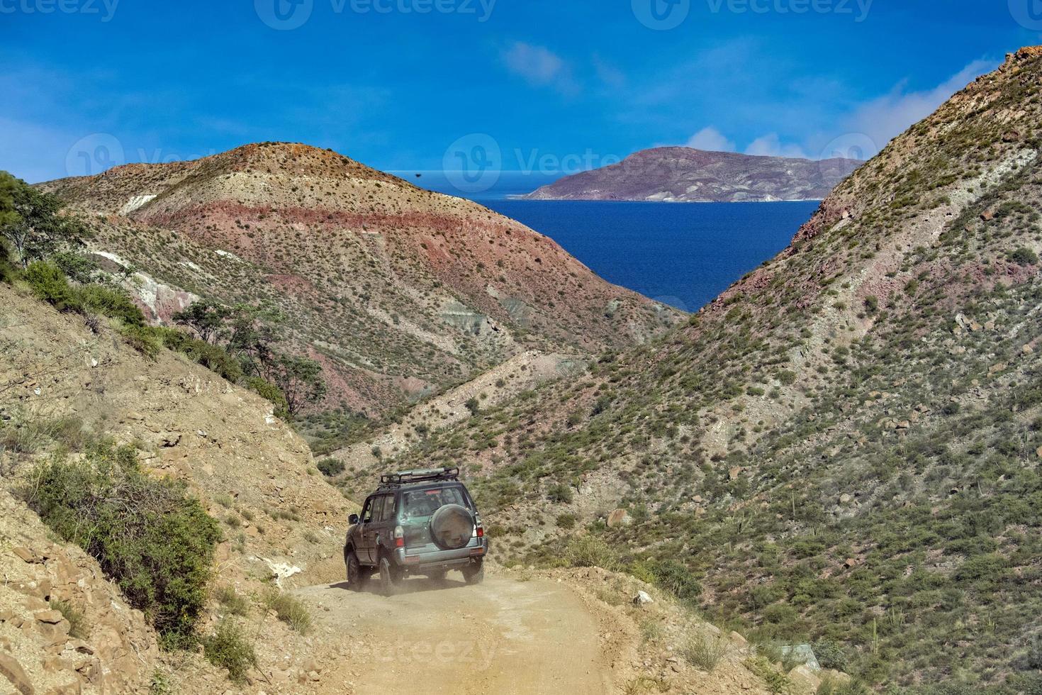 jeep car in baja california landscape panorama desert road with cortez sea on background photo