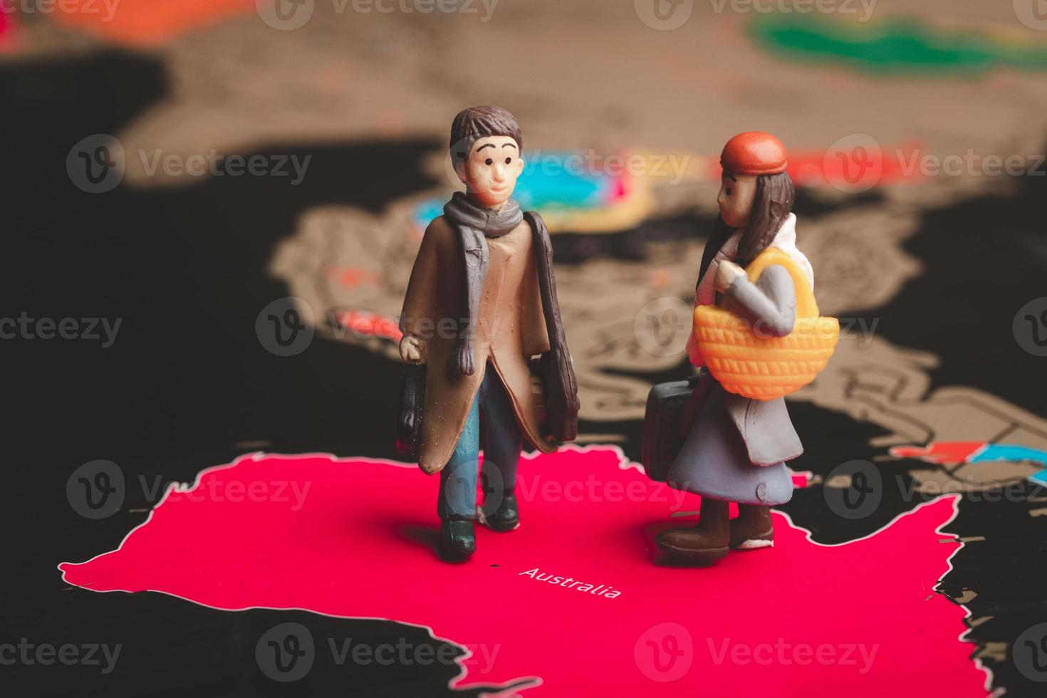 Miniature people with traveling concepts. Miniature traveler with baggage walking on the world map photo