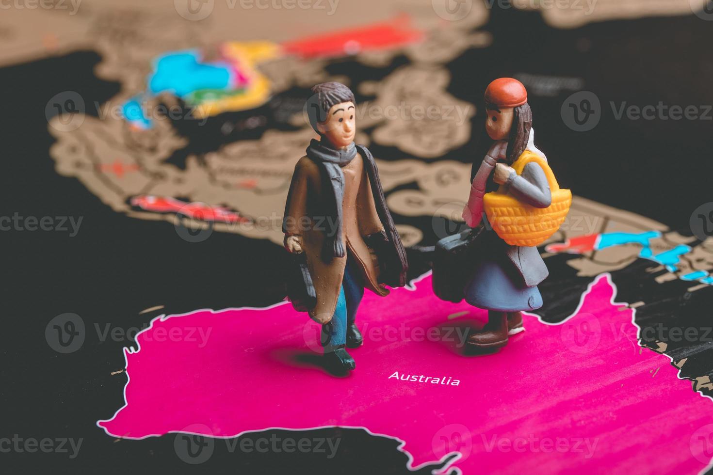 Miniature people with traveling concepts. Miniature traveler with baggage walking on the world map photo