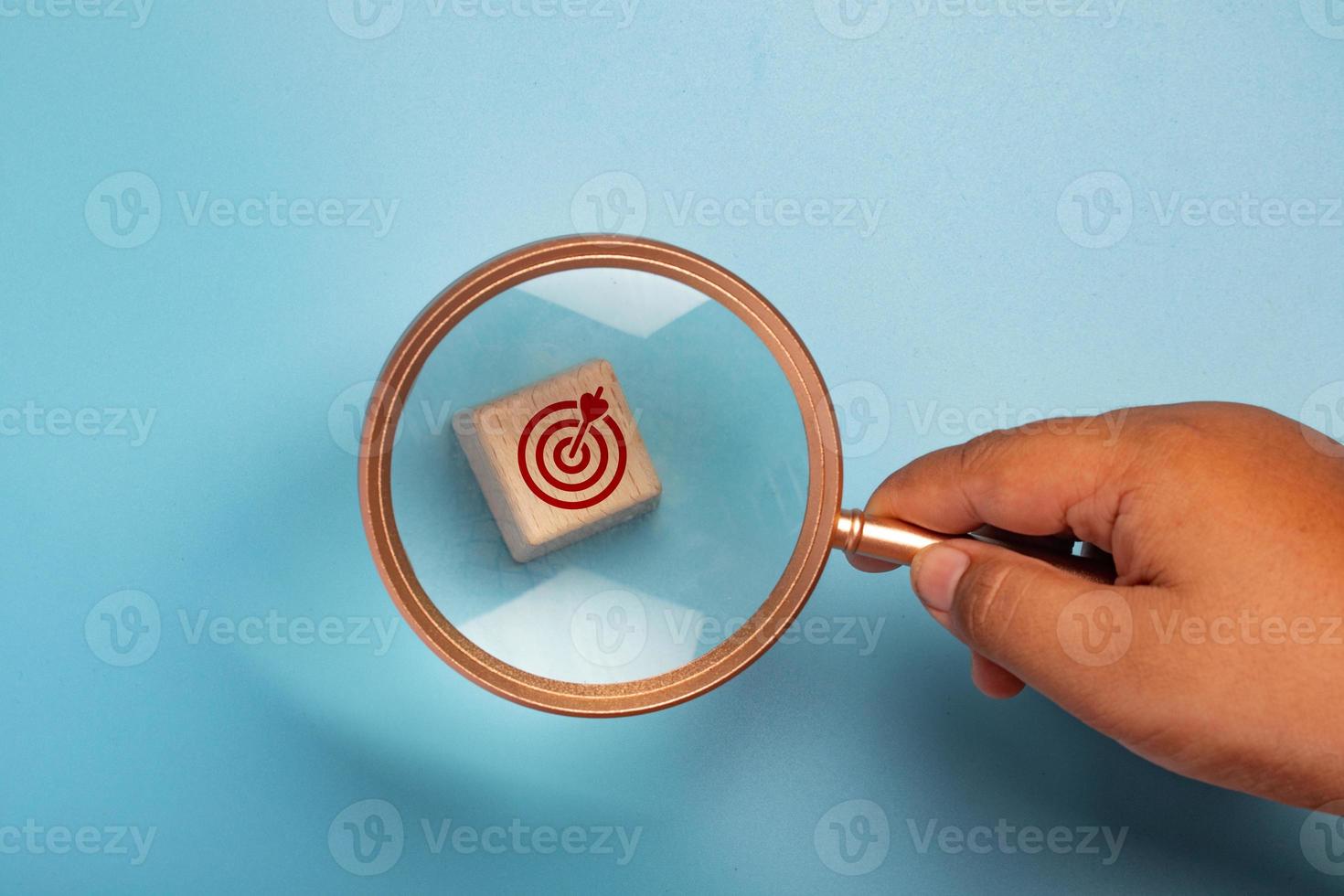 Magnifying glass with wooden block, target symbol.Work targeting concept. photo