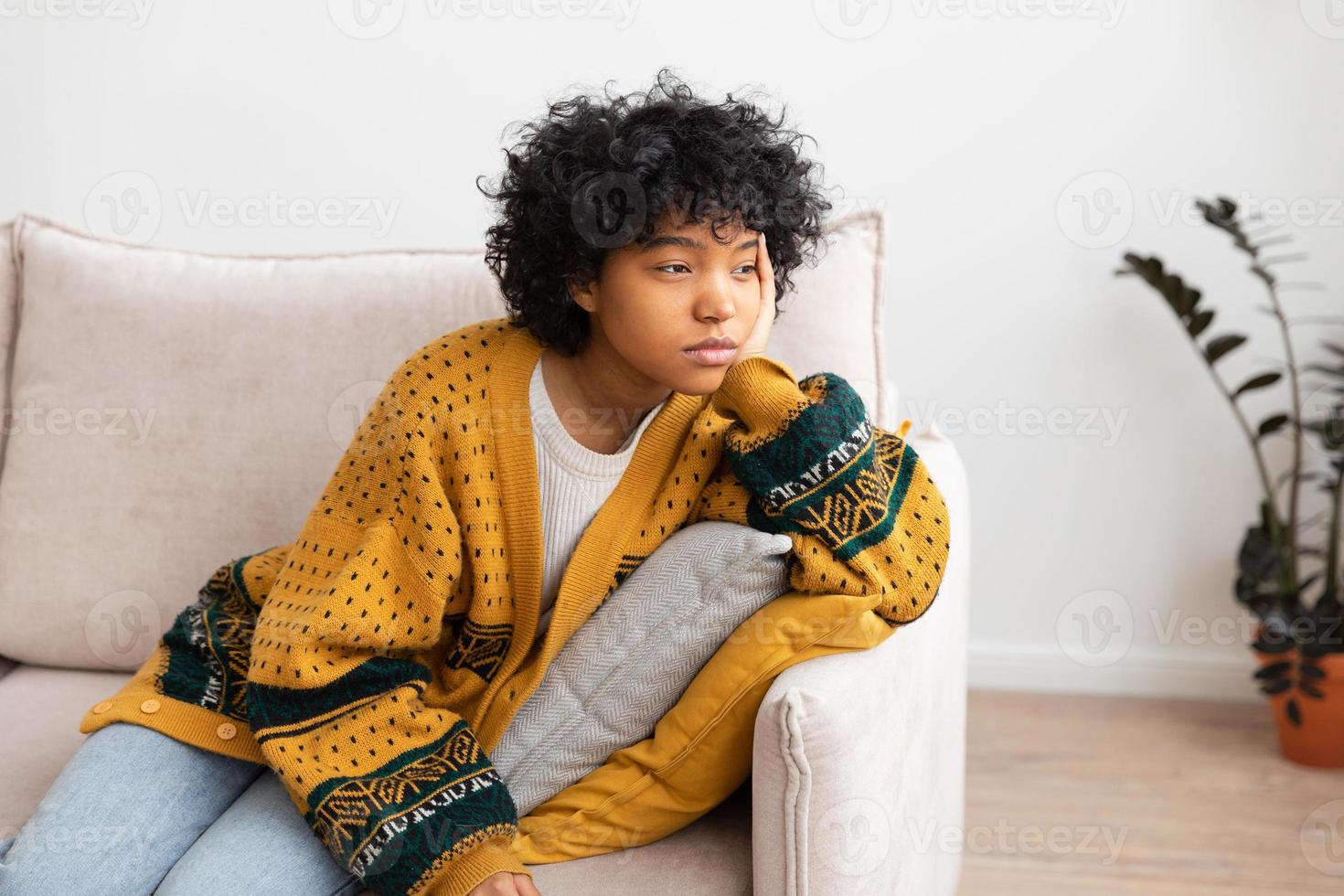 African american sad thoughtful girl at home. Young african woman feels depressed offended lonely upset suffers from abuse harassment heartbreak. Grieving violence victim has psychological problem. photo