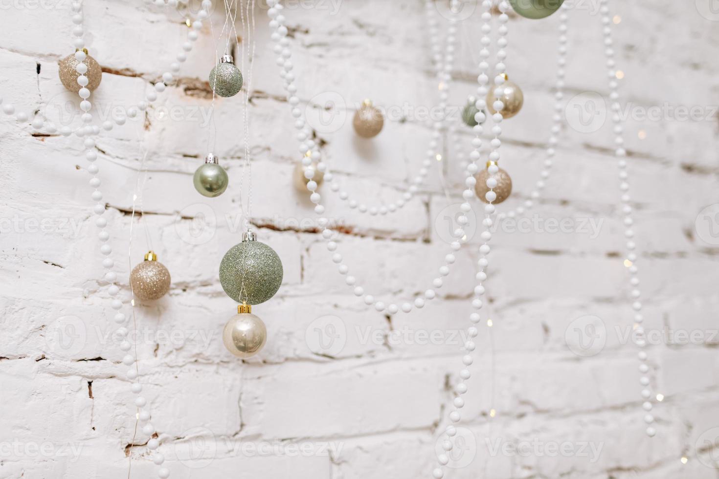 Christmas, New Year composition. Antler with shiny white, gold, green balls and pearl necklaces on white brick wall. Scandinavian cozy home decor. Happy Holidays, Template. Greeting card. 2023 photo