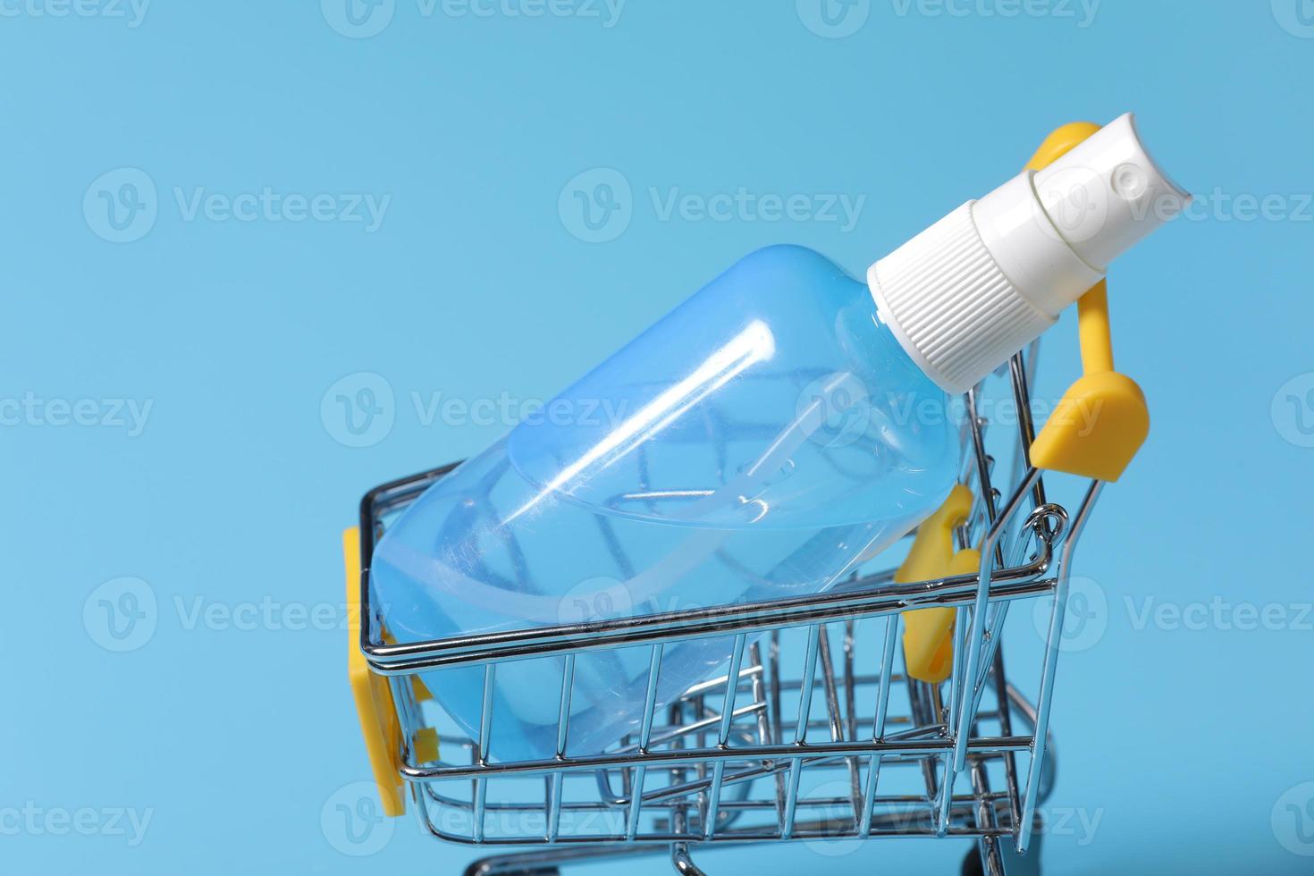Clear hand sanitizer in a clear pump bottle isolated on a blue background. Hand sanitizer is used for killing germs, bacteria and viruses photo