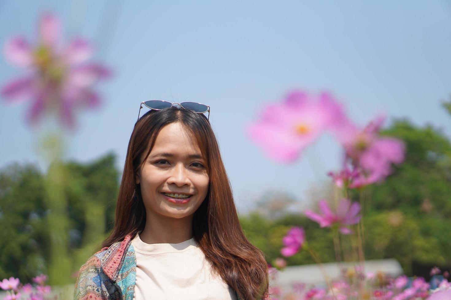 Happy Asian woman in cosmos flower garden photo