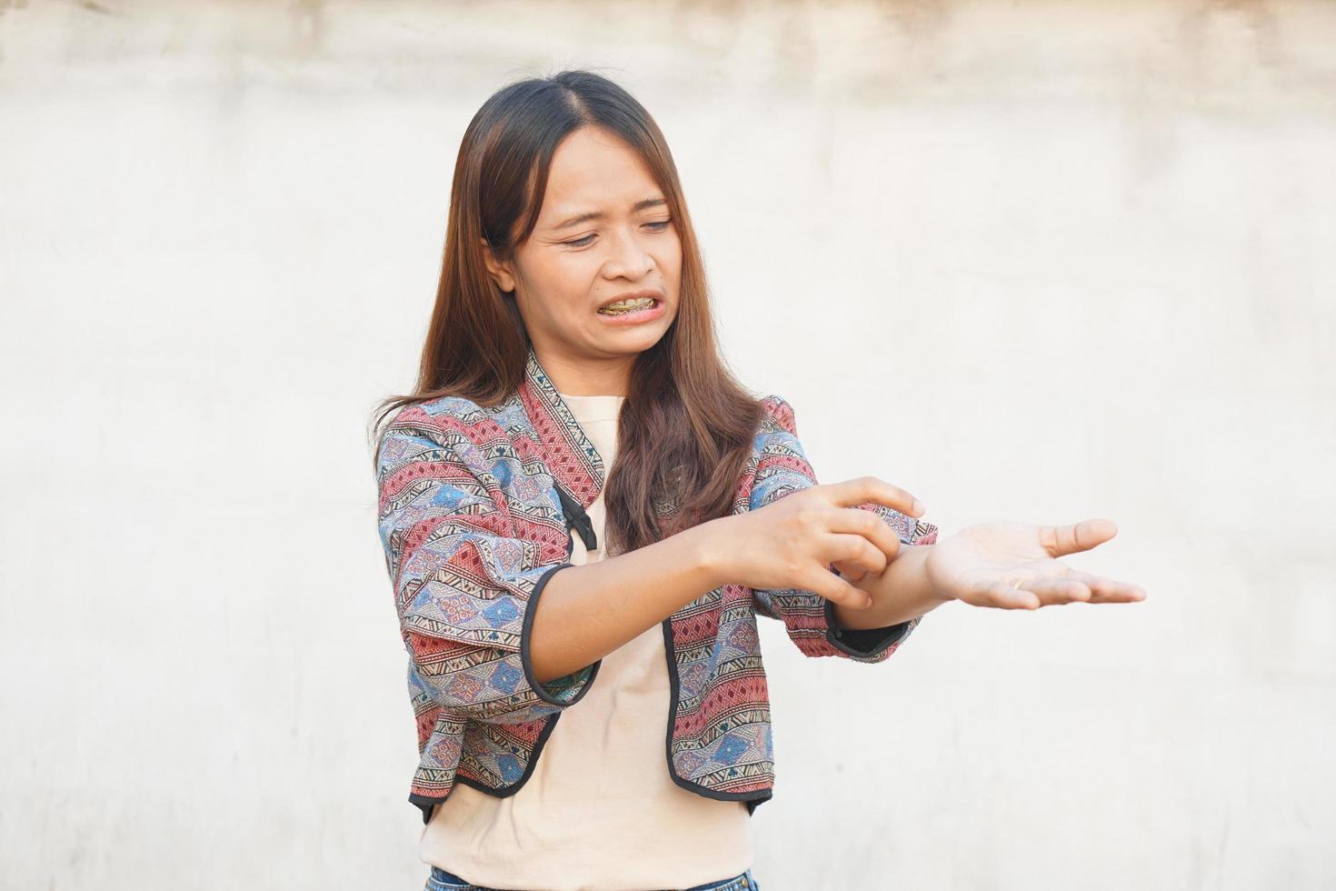 Asian woman having an itchy arm photo