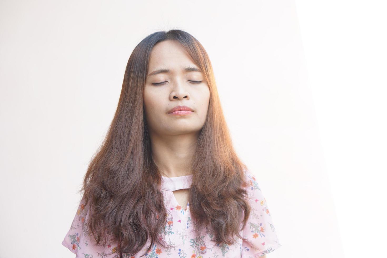 asiático mujer en pie con ojos cerrado, meditando foto