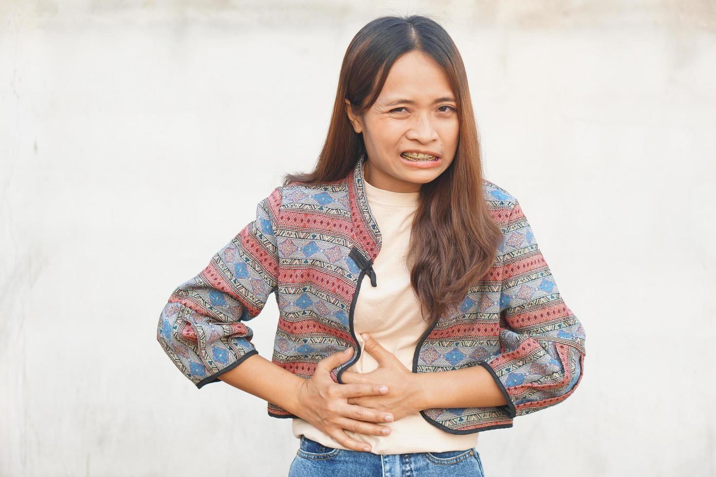 asiático mujer teniendo menstrual dolor foto