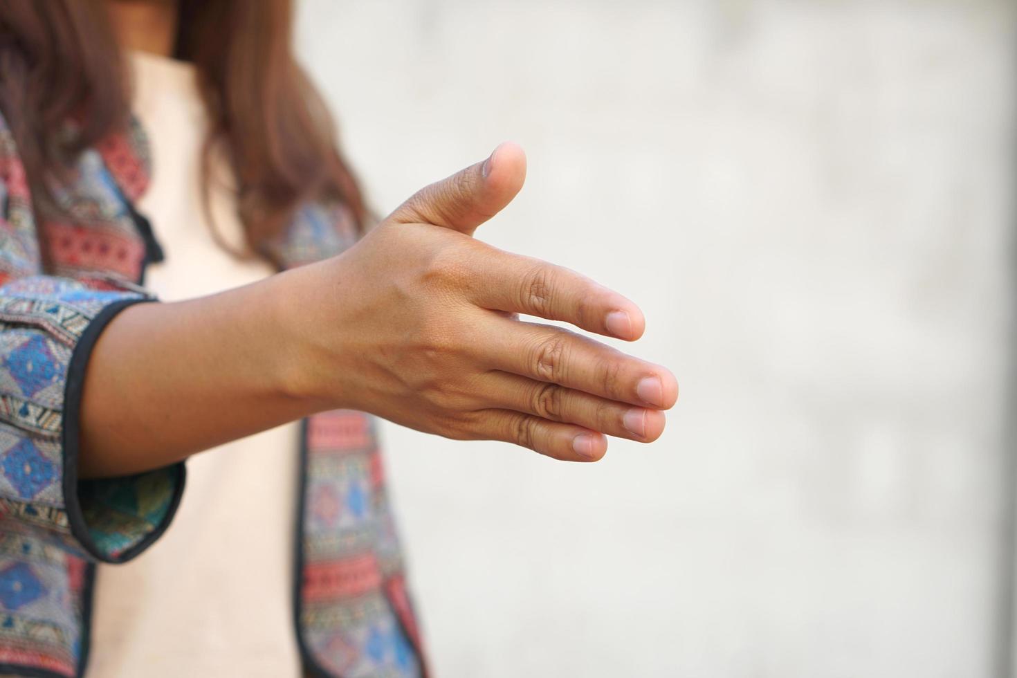 human hand reaching forward to shake hands photo