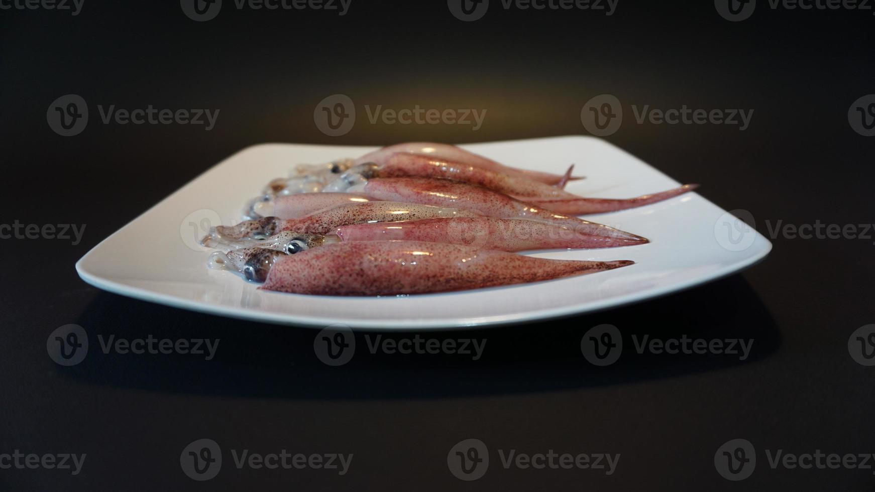 Squid Seafood on a plate on a black background. photo