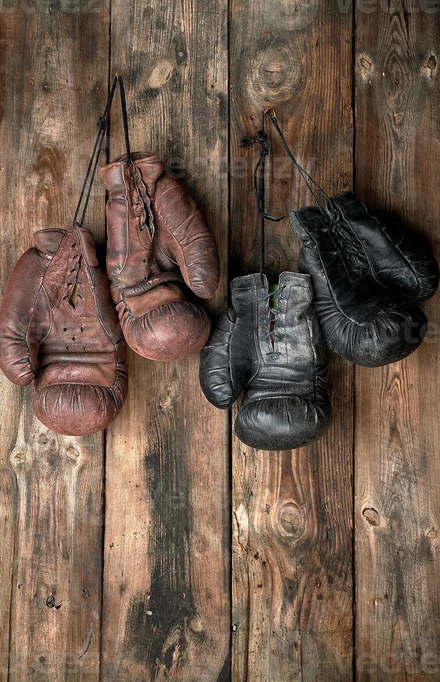 two pairs of leather vintage boxing gloves hanging on a nail photo