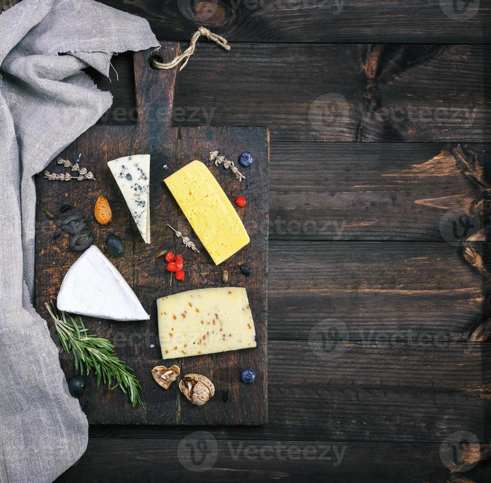 quesos en un marrón de madera tablero queso Brie, roquefort foto