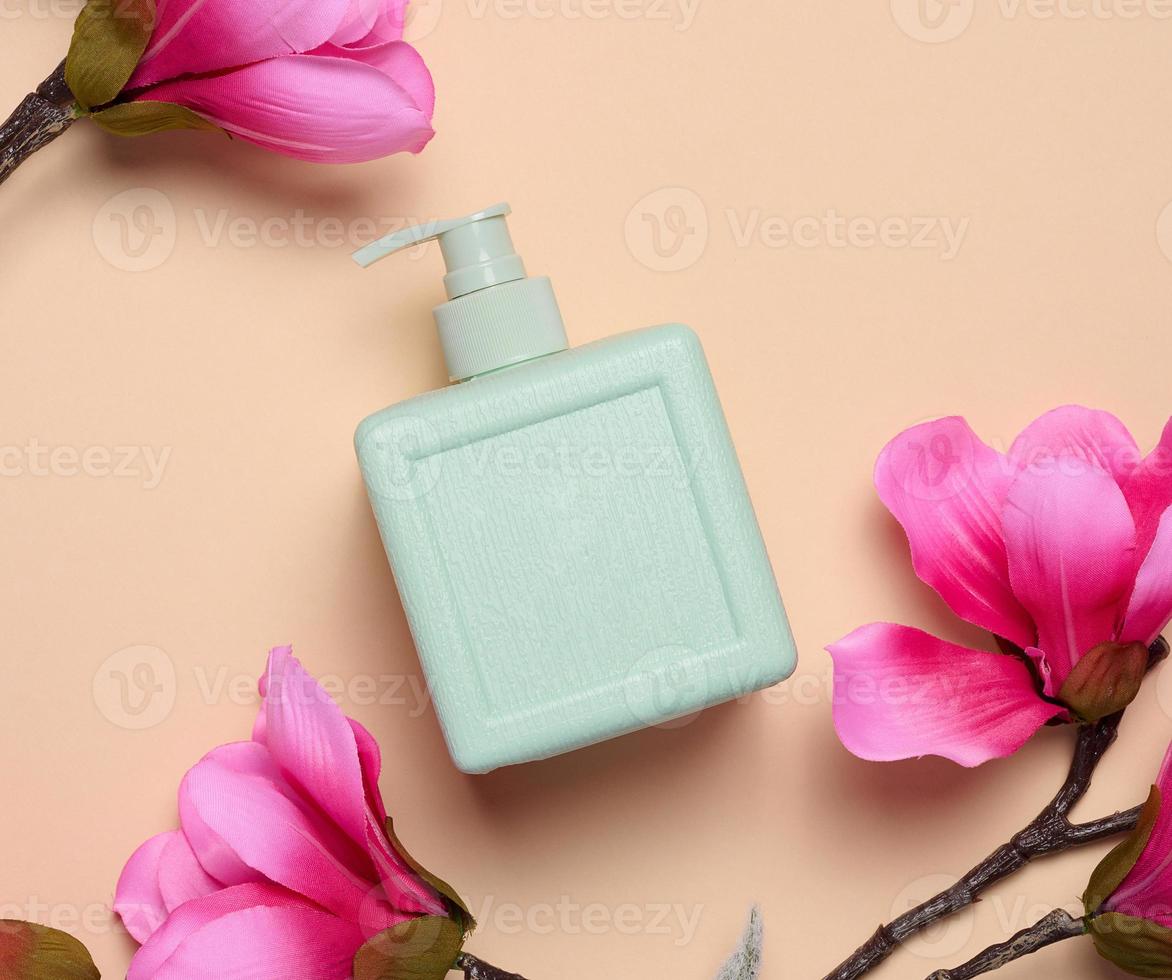 Plastic soap dispenser container on a beige background, cosmetics photo