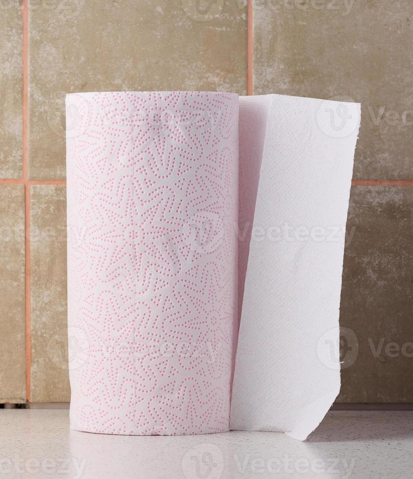 Soft white paper towel on a white table, disposable kitchen towel photo